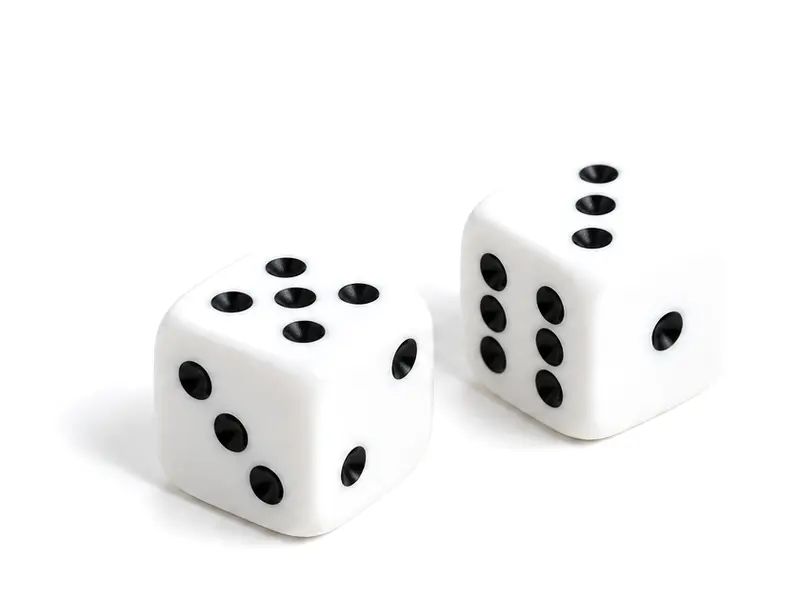 Two white dice with black pips on a white surface